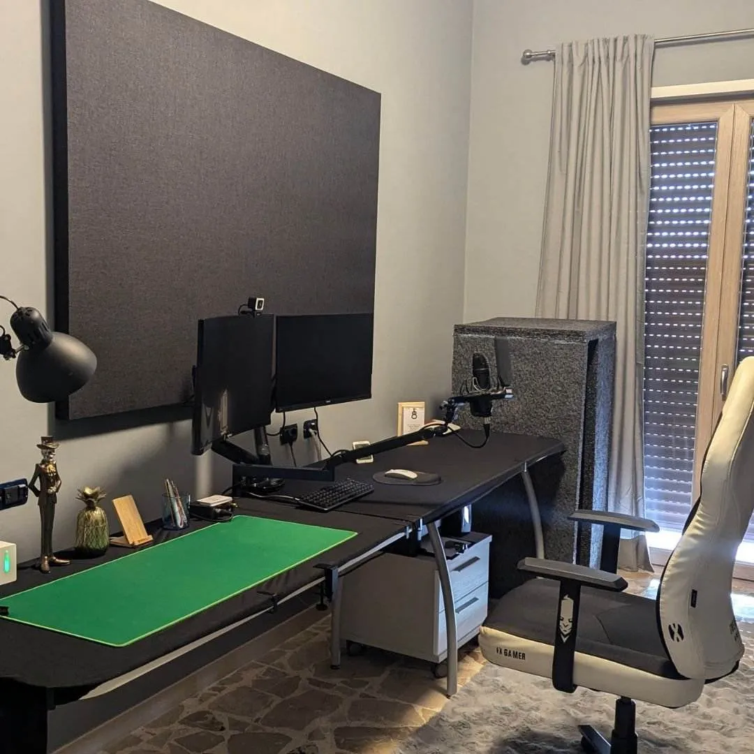 Lo studio: scrivania, doppio monitor, pannelli acustici e finestra